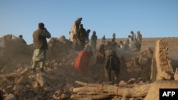 Warga Afghanistan membersihkan puing-puing dari rumah yang rusak pasca gempa bumi di Desa Sarbuland di distrik Zendeh Jan, Provinsi Herat, Afghanistan, 7 Oktober 2023. (Foto: AFP)
