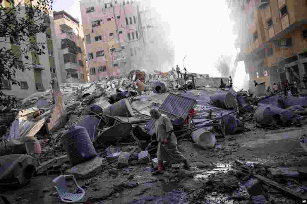 Palestinians inspect the rubble of a building after it was struck by an Israeli airstrike in Gaza City on Oct. 7, 2023.