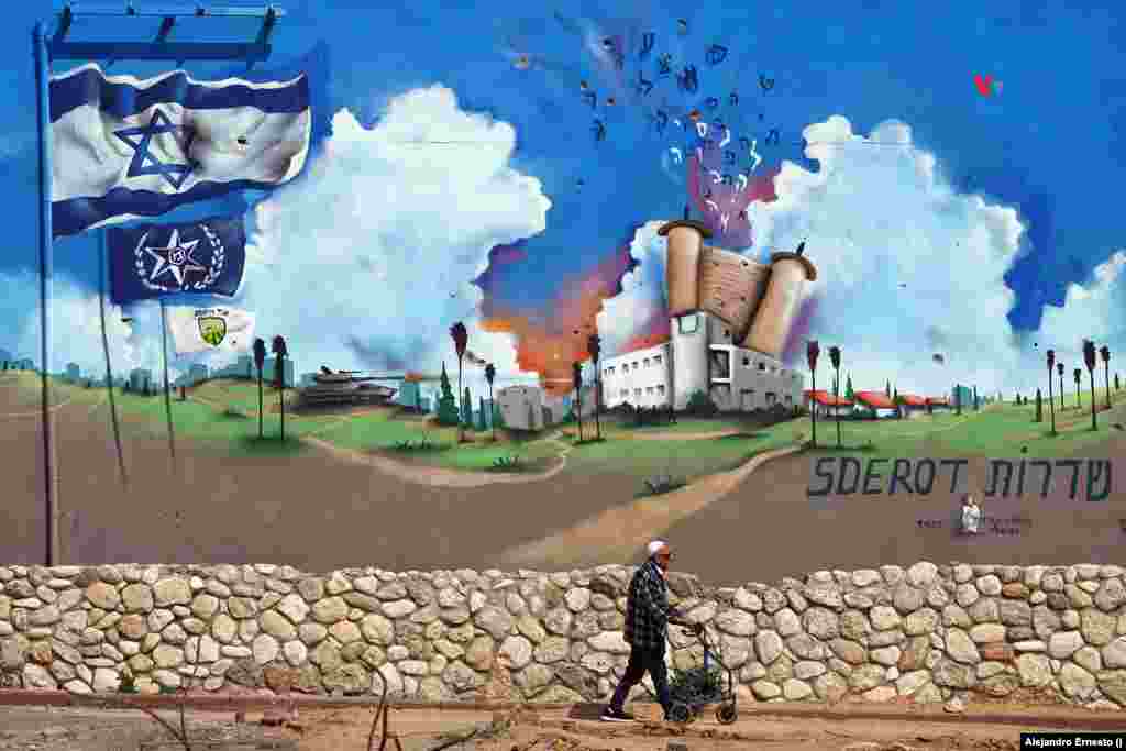 Un anciano camina junto a un mural pintado en lo que fue la estación de policía de Sderot totalmente destruida durante el ataque de Hamás.