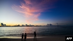 FILE - People walk along a beach at Vilimalé island in the the Maldives on Nov. 15, 2023. The Maldives is in hot water over calls to boycott the tropical destination, following derogatory remarks about Prime Minister Narendra Modi by government ministers.