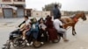 Palestinians fleeing north Gaza ride a horse-drawn cart as they move southward, as Israeli tanks roll deeper into the enclave, in the central Gaza Strip, Nov. 12, 2023.