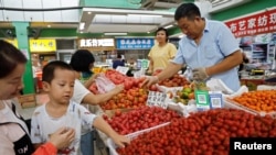 北京一家早市的顧客在挑撿西紅柿。（2023年8月9日）