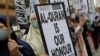 Seorang perempuan memegang poster bertuliskan, "Al-Qur'an adalah kehormatan kami" dalam aksi protes di depan kedutaan besar Swedia di Kuala Lumpur, Malaysia, pada 27 Januari 2023. (Foto: Reuters/Hasnoor Hussain)