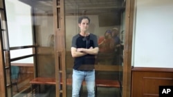  jurnalis Wall Street Journal, Evan Gershkovich, di tempatkan di ruang kaca di dalam ruang persidangan di Pengadilan Kota Moskow, Rusia, 22 Juni 2023. Dia adalah satu dari sekian banyak warga AS dan orang berkewarganegaraan ganda yang ditahan di Rusia.