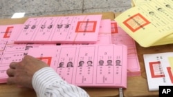 FILE - A staff sorts ballot papers at a polling station in Taipei, Taiwan, Jan. 13, 2024.