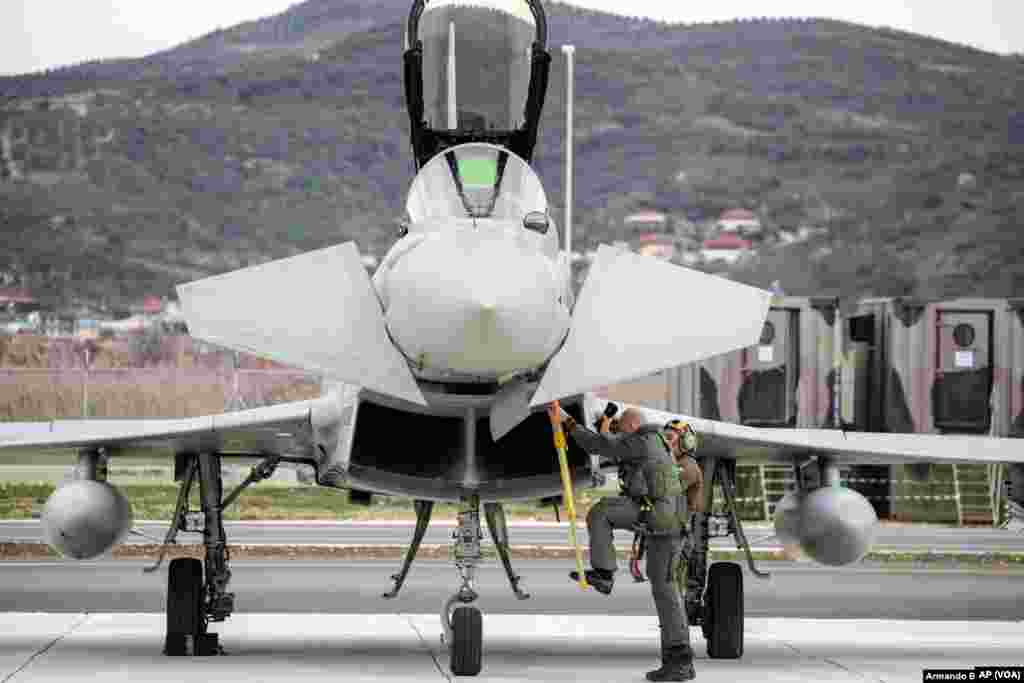 Un piloto se baja de un Eurofighter Typhoon italiano después de aterrizar durante la ceremonia de inauguración.