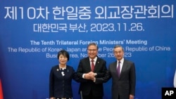 26일 한국 부산 해운대구 APEC누리마루에서 열린 한일중 외교장관회의에서 3국 외교장관이 손을 맞잡고 있다. 왼쪽부터 가미카와 요코 일본 외무상, 박진 한국 외교부 장관, 왕이 중국 외교부장