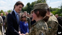 Perdana Menteri Kanada Justin Trudeau (kiri) dan Menteri Keuangan Chrystia Freeland (tengah) bertemu dengan sejumlah tentara Rusia di Kyiv, Ukraina, Sabtu, 10 Juni 2023. (Foto: Frank Gunn/the Canadian Press via AP)