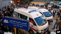 Jounalis ak manm fanmi yo rasanble bo kote anbulans La Kwa Wouj Libanez kap transpote kadav 2 jounalis rezo televizyon Arab Al-Mayadeenm TV nan Beirout, Liban 21 Nov. 2023.