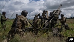 Sejumlah tentara Ukraina bersiap menembak posisi Rusia dengan howitzer M777 yang dipasok AS di wilayah Kharkiv, Ukraina, 14 Juli 2022. (Foto: Evgeniy Maloletka/AP Photo)