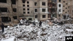 Police officers and local residents inspect damage outside a destroyed high-rise building following a Russian missile attack in central Kyiv, Jan. 3, 2024.
