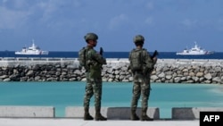 Tentara Filipina melihat kapal Penjaga Pantai Filipina di Laut Cina Selatan yang disengketakan pada 1 Desember 2023. (Foto: AFP)