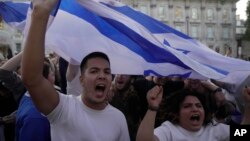 Manifestan rele slogan pandan yon veye Kominote Juif la nan vil Lond, Anglete, 9 Oktob, 2023.