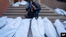 Warga Palestina berduka atas kematian para kerabat mereka dalam pemboman Israel di Jalur Gaza, di rumah sakit Khan Younis, Minggu 3 Desember 2023.