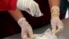 Químicos antinarcóticos prueban cocaína en una bolsa antes de una incineración de drogas ilegales incautadas en La Guaira, Venezuela, 29 de septiembre de 2016.