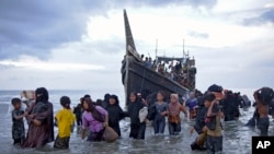 Sejumlah pengungsi Rohingya turun dari kapalnya yang berlabuh di Ulee Madon, Aceh Utara, 16 November 2023. (Foto: Rahmat Mirza/AP Photo)
