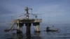 En esta imagen de archivo, un pescador pasa junto a una sonda de petróleo inactiva en el lago Maracaibo, en Venezuela, el 12 de octubre de 2022. (AP Foto/Ariana Cubillos, archivo)