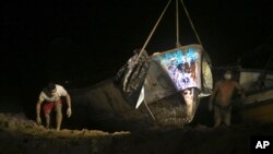 Un barco con varios cadáveres es sacado del agua por las autoridades en el puerto de Vila do Castelo en Braganca, Brasil, la madrugada del lunes 15 de abril de 2024. 