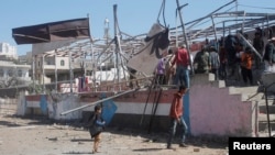 People gather at the scene of a blast which struck a military graduation parade in the town of al-Dhalea, Yemen, Dec. 29, 2019. 