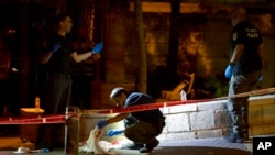 Penyelidik TKP polisi Israel bekerja di lokasi serangan penembakan yang melukai beberapa warga Israel di dekat Kota Tua Yerusalem, 14 Agustus 2022. (Foto: AP)