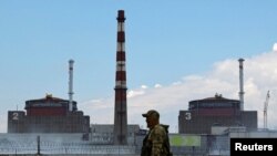 FILE: Seorang prajurit dengan bendera Rusia pada seragamnya berjaga di dekat PLTN Zaporizhzhia di luar kota Enerhodar yang dikuasai Rusia di wilayah Zaporizhzhia, Ukraina, 4 Agustus 2022. (REUTERS/Alexander Ermochenko/File Foto)