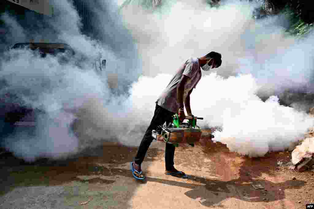 A front-line worker fumigates a neighborhood to ward off mosquitoes in Colombo, Sri Lanka.
