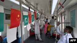 FILE - Passengers ride in a newly built Orange Line Metro Train, a metro project planned under the China-Pakistan Economic Corridor, a day after an official opening in the eastern city of Lahore, Oct. 26, 2020.