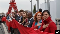 Climate activists carry a red banner during a demonstration at the COP21, United Nations Climate Change Conference, in Le Bourget, north of Paris, Friday, Dec. 11, 2015. (AP Photo/Michel Euler)
