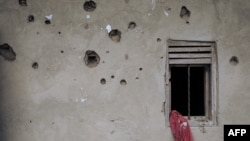 FILE - The wall of a house riddled with bullets is seen in Nzenga, which has been repeatedly attacked by the armed group Allied Democratic Forces (ADF), Beni territory, northeastern Democratic Republic of Congo, May 24, 2021.