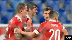 Mosani ya kati na équipie ya Russie Aleksandr Erokhin azali kosepela na baninga baye ba Russie nsima na mongete na ba qualifications ya Mondial Qatar 2022 kati na Russie na Chypre na Sait-Petersbourg, 11 novembre 2021.