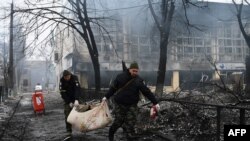 Petugas polisi memindahkan mayat seorang korban tewas dalam serangan Rusia pada sebuah menara televisi di Kyiv, Ukraina, pada 2 Maret 2022. (Foto: AFP/Aris Messinis)