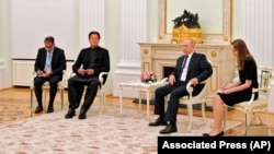 Russian President Vladimir Putin, center right, and Pakistan's Prime Minister Imran Khan, center left, talk during their meeting in Moscow, Feb. 24, 2022.