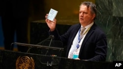 Duta Besar Ukraina untuk PBB Sergiy Kyslytsya memegang salinan Piagam PBB ketika berbicara dalam pertemuan darurat pada Sidang Umum PBB di New York, pada 2 Maret 2022. (Foto: AP/Seth Wenig)
