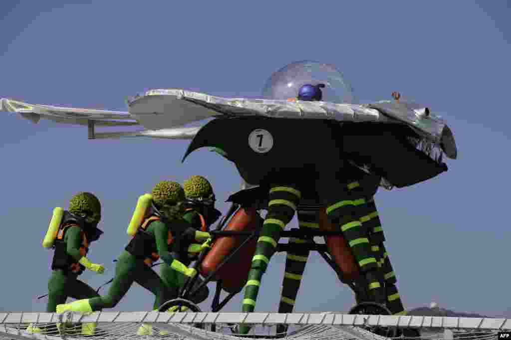 Participants dressed as alien characters from the film 'Mars Attacks!' launch their flying contraption during the Red Bull Flugtag event in Hong Kong.