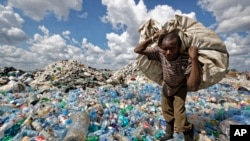 ILUSTRASI - Seorang pria berjalan di atas gunungan botol-botol plastik sambil membawa sekarungnya untuk dijual untuk didaur ulang setelah menimbangnya di tempat pembuangan sampah di daerah kumuh Dandora, Nairobi, Kenya, 5 Desember 2018. (AP/Ben Curtis, File)
