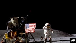 Dalam foto yang dirilis April 1972 oleh NASA, astronot John Young memberi hormat kepada bendera AS di tempat pendaratan Descarte di Bulan saat melakukan aktivitas pertama Apollo 16.

