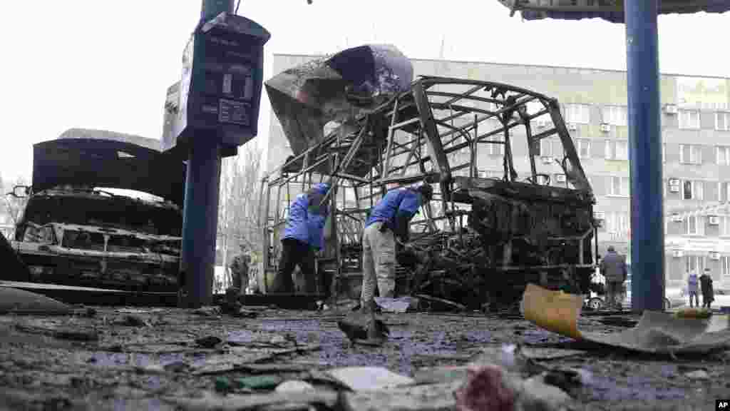 Para anggota Organisasi Keamanan dan Kerjasama Eropa (OSCE) menyelidiki lokasi penembakan antara pemberontak pro-Rusia dan pasukan pemerintah di Donetsk, Ukraina timur (11/2). (AP/Petr David Josek)