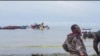 Rescatistas en botes se ven en torno a la cola de un avión de pasajeros de Precision Air en el Lago Victoria, en Bukoba, en el oeste de Tanzania, el domingo 6 de noviembre de 2022.