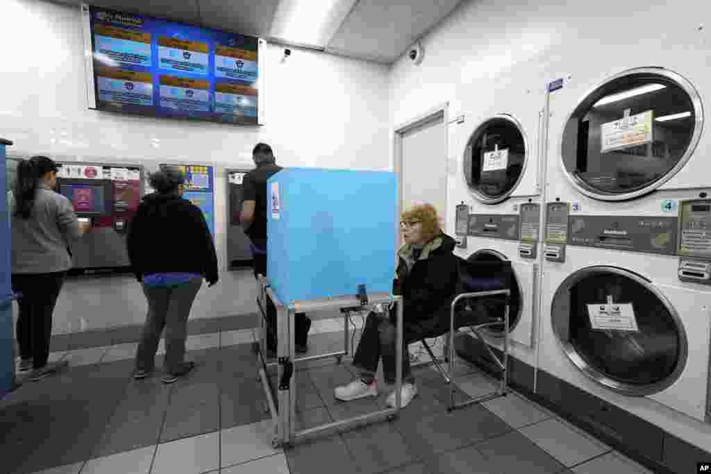 Jeanette Buchanan works on her electronic ballot as patrons at the Su Nueva Lavanderia put cash on laundry cards near Chicago's Midway Airport, Nov. 8, 2022, in Chicago, Illinois.