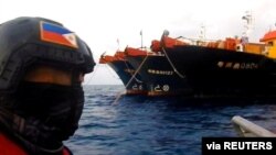 Personal de la Guardia Costera de Filipinas observan barcos chinos con presuntos milicianos en el Mar de la China Meridional a mediados de abril de 2021.