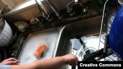 Washing dishes in a sink.