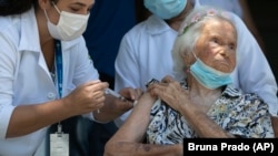 Zelia de Carvalho Morley, yang berusia 106 tahun, mendapat vaksin Covid-19, CoronaVac, buatan Sinovac, di rumah lansia tempat dia tinggal di Rio de Janeiro, Brazil, Rabu, 20 Januari 2021. (Foto: AP)
