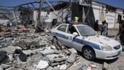 Debris covers the ground and an emergency vehicle after an airstrike at a detention center in Tajoura, east of Tripoli in Libya, July 3, 2019. An airstrike hit the detention center for migrants, killing several.
