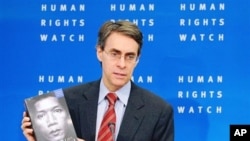 Human Rights Watch executive director Kenneth Roth shows the group's annual review during a media conference. Human Rights Watch report the silence and complicity of the U.S., U.N., EU and major European nations in dealing with rights-abusing developing 