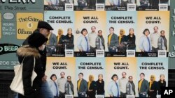  In this Wednesday, April 1, 2020 file photo,People walk past posters encouraging participation in the 2020 Census in Seattle's Capitol Hill neighborhood.