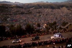 Paus Fransiskus dalam kendaraan 'Popemobile' (kanan) menyapa warga yang menyambut kedatangannya di Bolivia, Rabu (8/7)