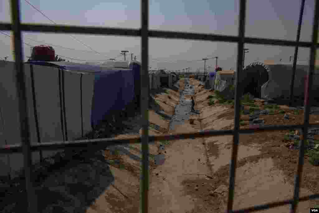 A young boy plays in a dried canal that crosses Roj Camp on Oct. 13, 2024. (Diego Baravelli/VOA)