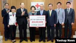 5일 서울 대한적십자사를 방문한 김인수 한국SGI 이사장(오른쪽 네번째)이 김선향 대한적십자사 부총재(왼쪽 네번째)에게 북한 아동 및 다문화 가정 지원을 위한 기부금 5천만 원을 전달했다. (자료사진)