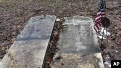 Las lápidas de Josiah Clark, un soldado de la Guerra Revolucionaria, y su esposa, descansan en el suelo después de que fueron retiradas, el 10 de diciembre de 2019, de un cementerio cerca del borde de un río en erosión en Weybridge, Vermont, EEUU.