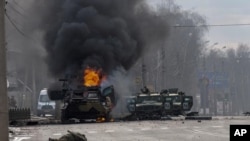 ARCHIVO - Un vehículo blindado de transporte de personal ruso arde en medio de vehículos utilitarios ligeros dañados y abandonados después de los combates en Kharkiv, la segunda ciudad más grande en Ucrania, el 27 de febrero de 2022. 